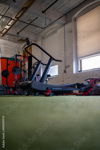 Portrait view of cardio equipment and lifting rack at indoor performance fitness studio.