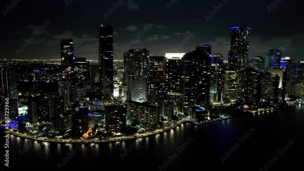 Night Scape Downtown At Miami Florida United States. Aerial View Of A High-Rise Buildings And Traffic Showcasing Urban Life. Building Clouds Sky Illuminated Urban. Town Outdoor Downtown Panning Wide.