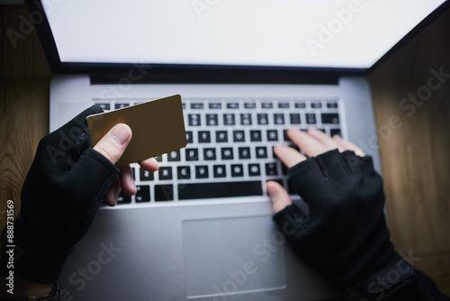 Laptop, credit card and hands of hacker for cyber crime, financial fraud and cloning for identity theft or breach. Person, dark and online for hacking or malware attack, phishing and account takeover