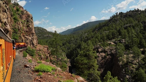 Durango and Silverton Train under river cliffs Narrow Gauge Railroad steam coal Colorado Rocky Mountains Neddleton Need Creek Chicago Basin Purgatory Trail Summer July bluesky forest follow pan