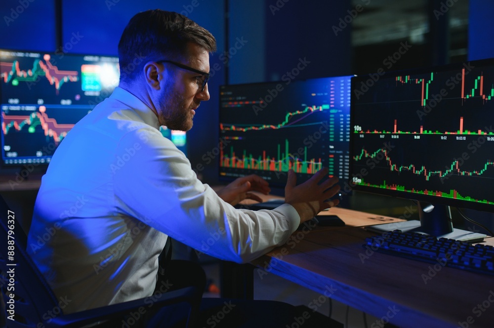 businessman comparing stock market data late in the evening businessman comparing stock market data late in the evening