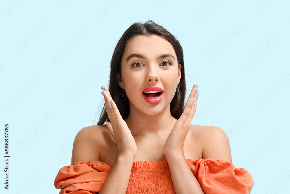 Beautiful young surprised woman on blue background Beautiful young surprised woman on blue background