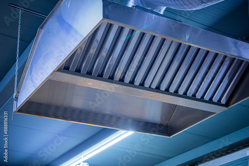 Tableau sur toile Stainless steel exhaust hood with grease trap close-up in a large industrial kit