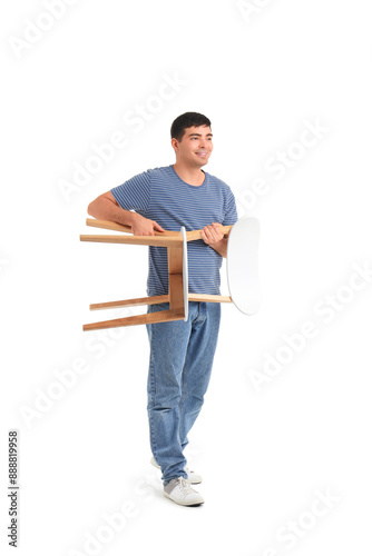 Young man carrying chair on...