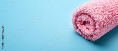  A pink towel lies atop a blue table, beside a bottle of toothpaste on a blue surface