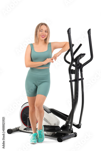 Young woman near exercising bike on white background