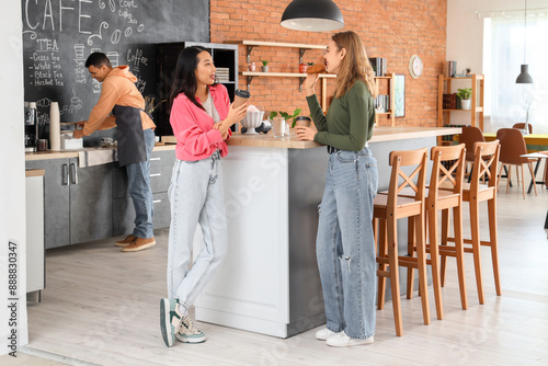 Young women with coffee and croissant in cafe