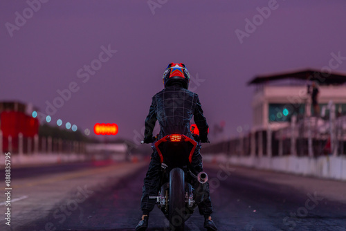 Motorcylce rider protective cloth with motorcycle ready to race, Motorcycle on the asphalt race track. © Kalyakan