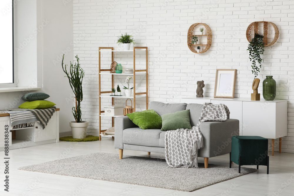 Obraz premium Modern interior of living room with sofa, pouf and soft pillows