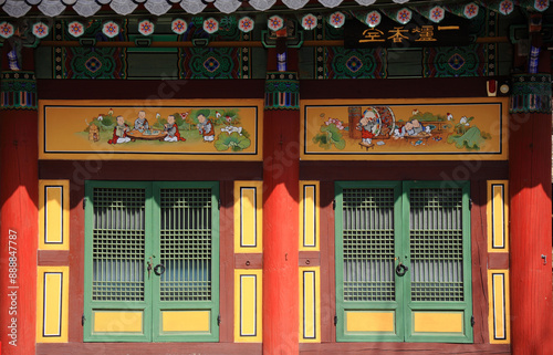 Sinpyeong-ri, Goseong-gun, Gangwon-do, South Korea - March 4, 2023: Front view of window door and mural with colorful Dancheong on a buddhist sanctuary of Hwaamsa Temple 