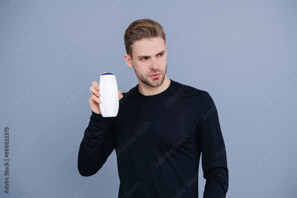 Man hold aftershave. Man with unbranded product. Haircare and skincare. Aftershave cosmetics product. Anti-dandruff shampoo. Offer aftershave. Presenting cosmetics product for men Man hold aftershave. Man with unbranded product. Haircare and skincare. Aftershave cosmetics product. Anti-dandruff shampoo. Offer aftershave. Presenting cosmetics product for men