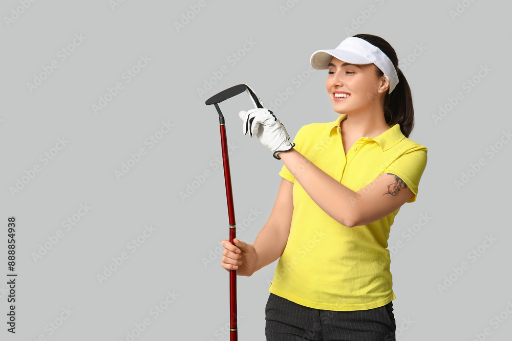 Beautiful female golfer on grey background Beautiful female golfer on grey background