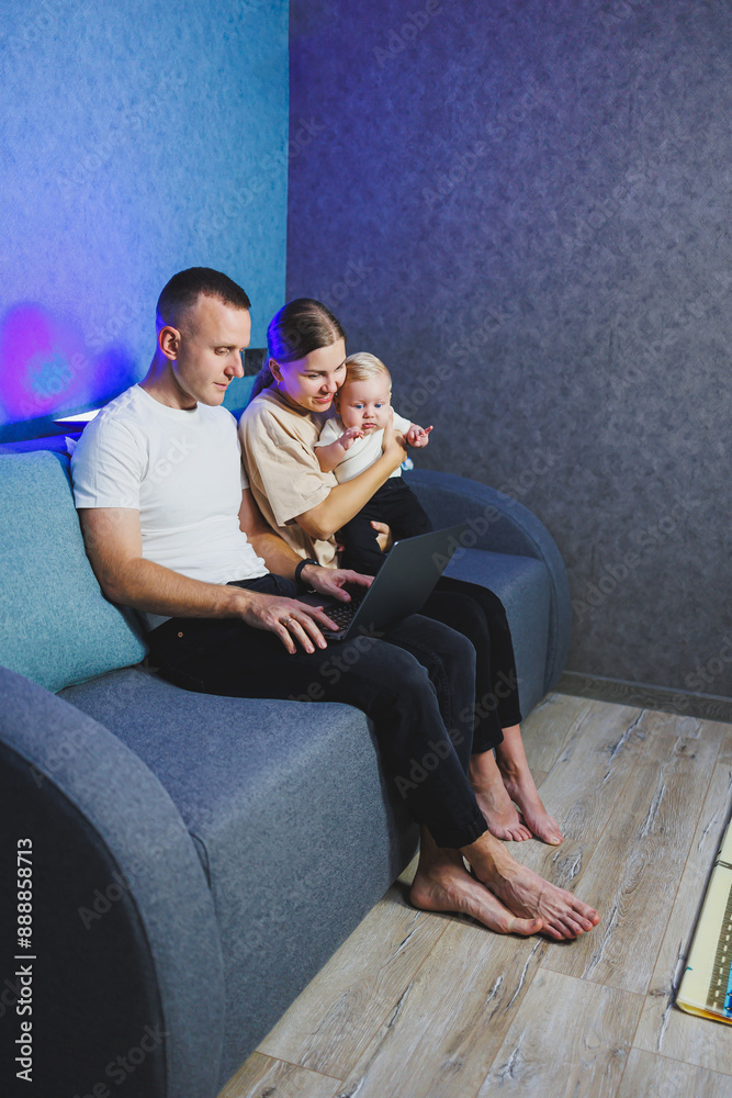 Young married couple having fun playing with cute little baby in modern living room together. Smiling parents, mom and dad, enjoying spending time with their son at home Young married couple having fun playing with cute little baby in modern living room together. Smiling parents, mom and dad, enjoying spending time with their son at home
