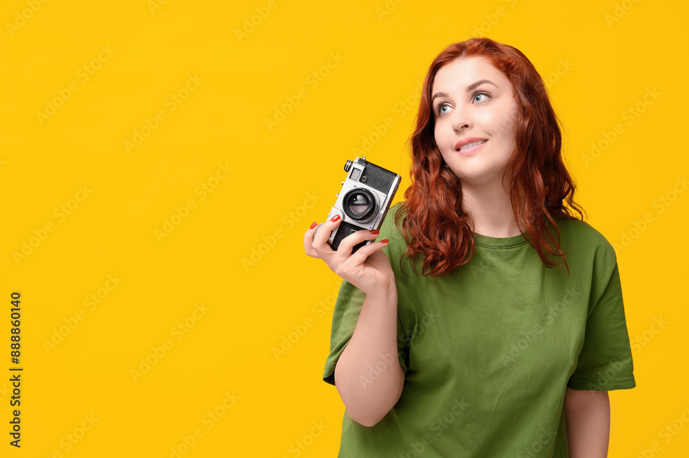 Beautiful young redhead woman with camera on yellow background Beautiful young redhead woman with camera on yellow background