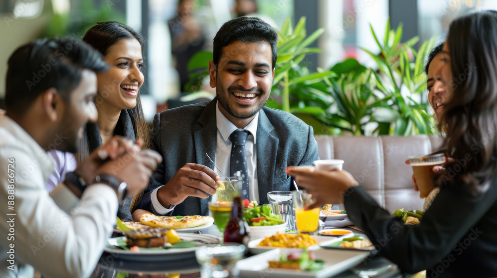 Cheerful Indian managers from different ethnic backgrounds enjoying a team lunch in a trendy office Cheerful Indian managers from different ethnic backgrounds enjoying a team lunch in a trendy office