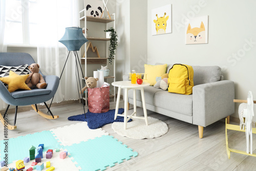 Interior of children's room with backpack on sofa and table