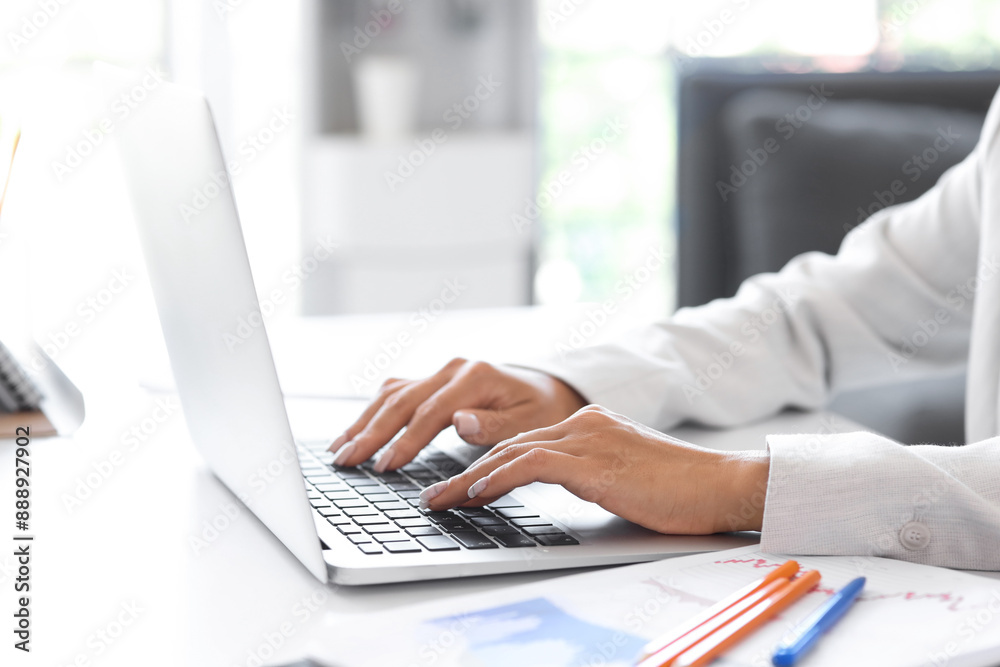 Businesswoman working with laptop at table in office, closeup Businesswoman working with laptop at table in office, closeup