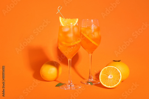 Fototapeta Naklejka Na Ścianę i Meble -  Glasses of Aperol spritz cocktail and fruits on orange background