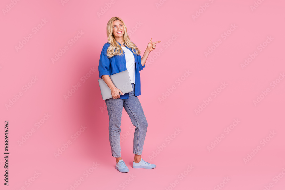 Full length photo of shiny attractive lady dressed blue jacket holding modern device showing empty space isolated pink color background Full length photo of shiny attractive lady dressed blue jacket holding modern device showing empty space isolated pink color background