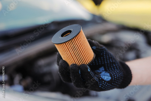 Auto mechanic holds an oil filter for gasoline cars in his hand. Oil change.