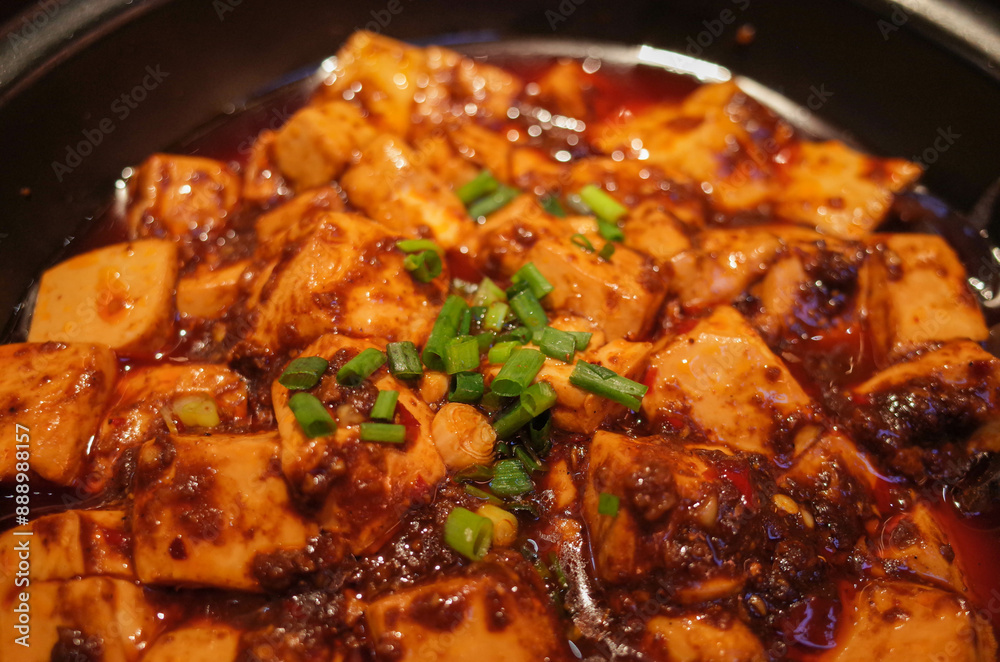 Closeup of mapo tofu in a casserole pan. Bean curd Sichuan style. MaPo Tofu,stir-fried tofu in hot sauce. Closeup of mapo tofu in a casserole pan. Bean curd Sichuan style. MaPo Tofu,stir-fried tofu in hot sauce.