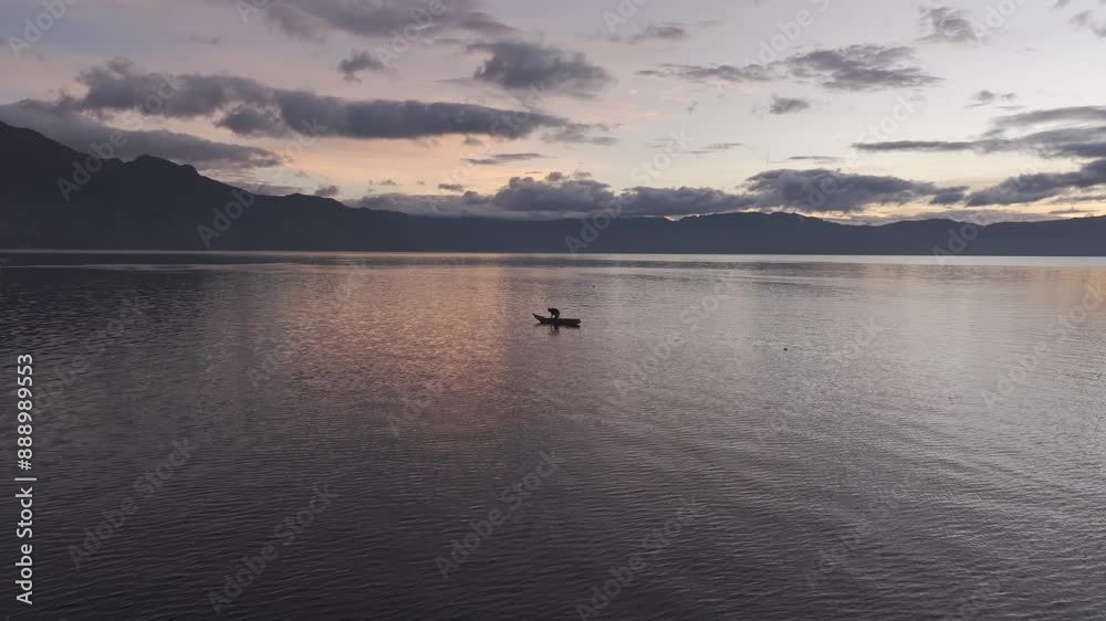 Aerial view of serene Lake Atitlan at sunrise with fishing boat, San Pedro La Laguna, Guatemala. Aerial view of serene Lake Atitlan at sunrise with fishing boat, San Pedro La Laguna, Guatemala.