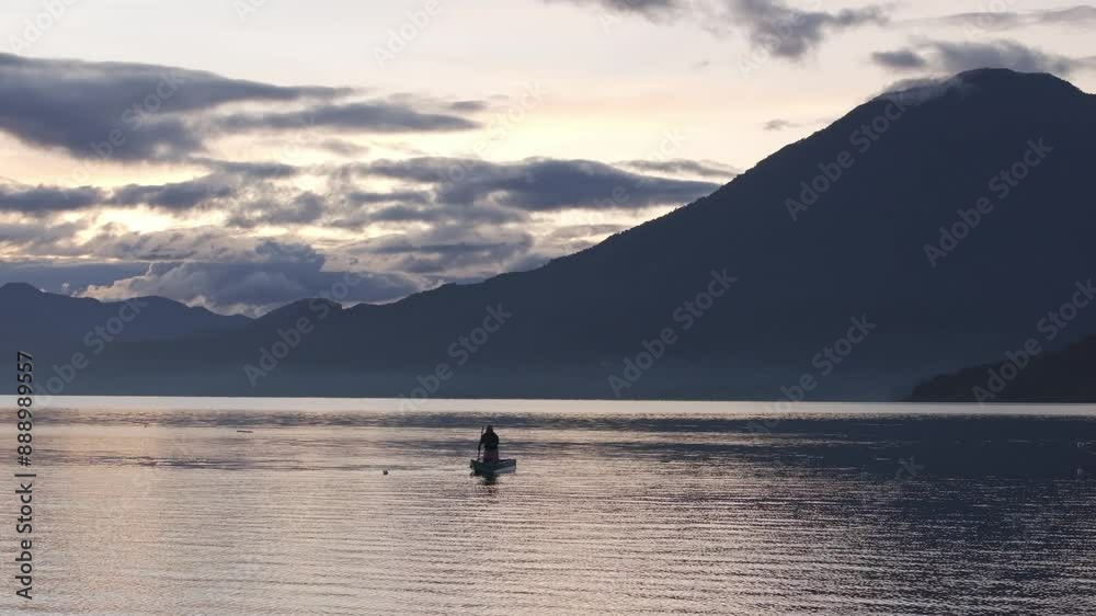 Aerial view of serene lake at sunrise with fishing boats and misty mountains, Lake Atitlan, San Pedro La Laguna, Guatemala. Aerial view of serene lake at sunrise with fishing boats and misty mountains, Lake Atitlan, San Pedro La Laguna, Guatemala.