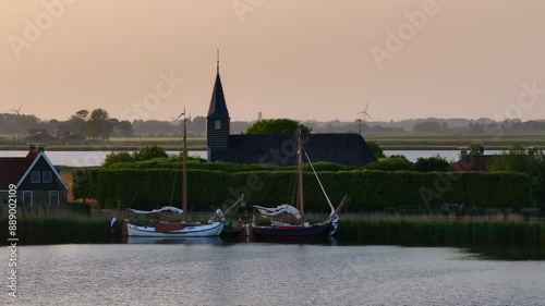 Aerial view of serene village by the lake with church, boats, and trees, Sandfirden, Friesland, Netherlands. photo