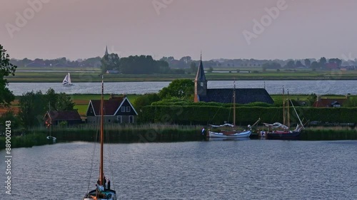 Aerial view of serene village with church, boats, and lake at dusk, Sandfirden, Friesland, Netherlands. photo