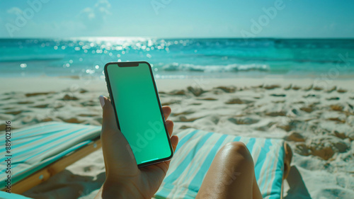 Fototapeta Naklejka Na Ścianę i Meble -  Green screen smartphone mockup on a tropical beach.