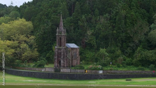 Aerial view of abandoned old church by lake and forest, Capela de Nossa Senhora das Vitorias, Azores, Portugal. photo