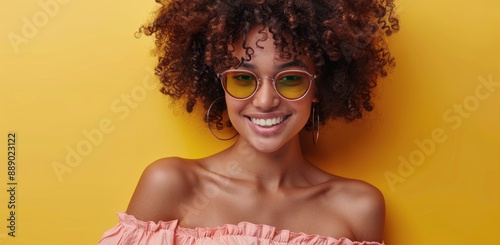 Smiling Woman With Curly Hair Wearing Pink Sunglasses Against Yellow Background