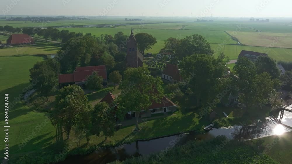 Aerial view of peaceful countryside village with church and river, Allingawier, Friesland, Netherlands. Aerial view of peaceful countryside village with church and river, Allingawier, Friesland, Netherlands.