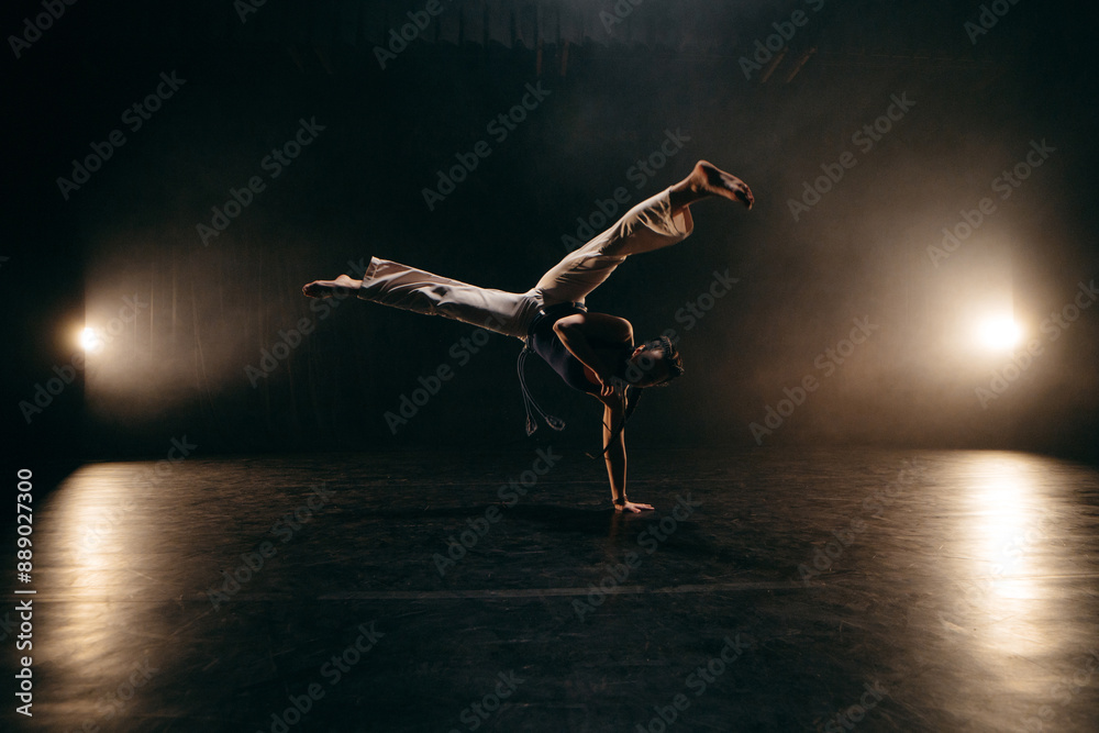 Female fighter training capoeira on black background Female fighter training capoeira on black background