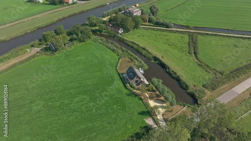 Aerial view of rural farm with river, house, field, and grass, Allingawier, Friesland, Netherlands. photo