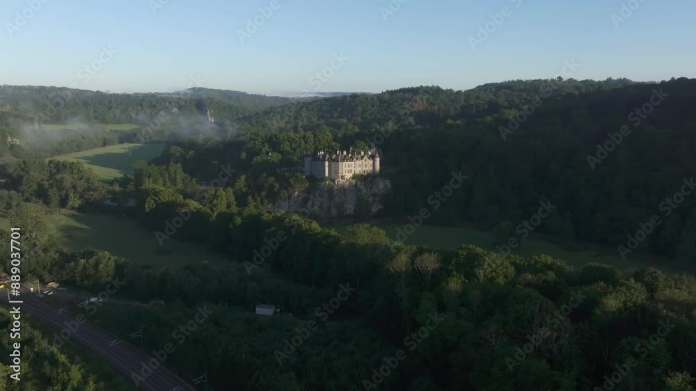 Aerial view of Medieval castle and forest in misty valley by river, Walzin, Dinant, Belgium.