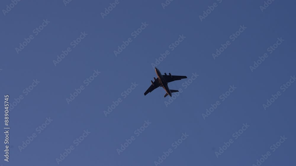 Silhouette of commercial airplane flying high against clear blue sky, showcasing aviation and travel. Silhouette of commercial airplane flying high against clear blue sky, showcasing aviation and travel.