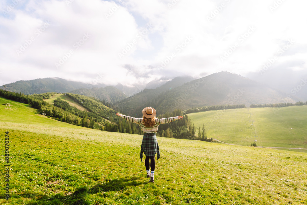 Happy woman walking green grass field, admiring landscape. Adventure and travel exploring Happy woman walking green grass field, admiring landscape. Adventure and travel exploring