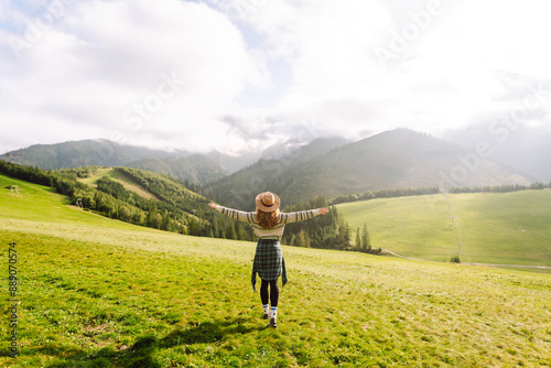 Happy woman walking green grass field, admiring landscape. Adventure and travel exploring