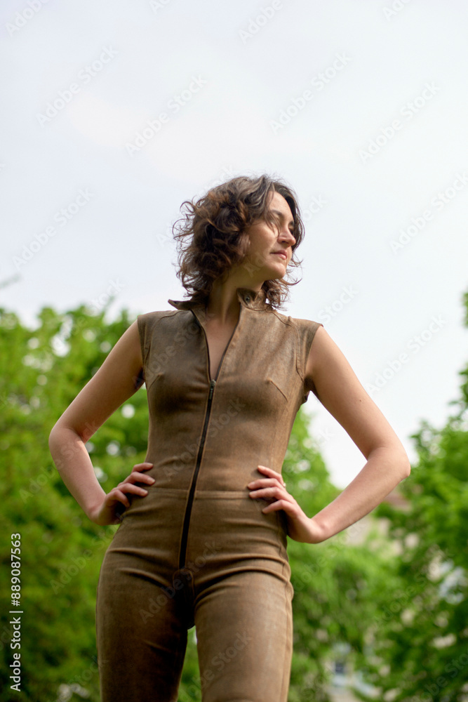 Confident woman standing outdoors in a stylish brown jumpsuit. Confident woman standing outdoors in a stylish brown jumpsuit.