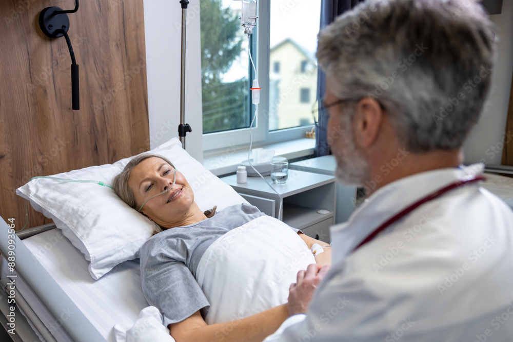 Fototapeta premium Doctor talking to a patient and holding her hands