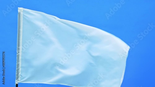 Slow motion video of white flag waving on blue background