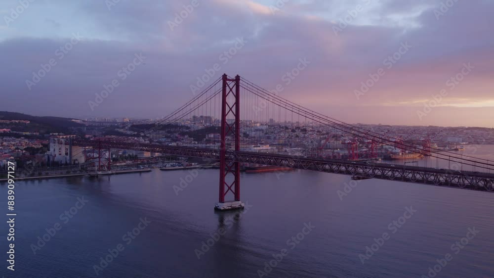 Aerial view of Ponte 25 de Abril bridge at sunset over Tagus River, Lisbon, Portugal.