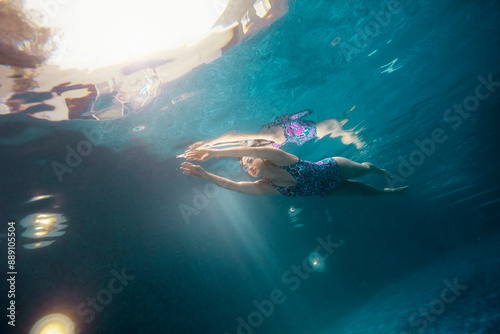 Underwater view of a woman swimming gracefully and powerfully through the water photo