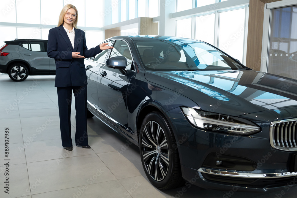 Pretty blonde young woman working in a car showroom Pretty blonde young woman working in a car showroom