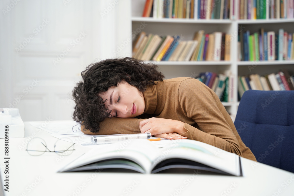 Exhausted woman architect working with blueprints in library and falling asleep Exhausted woman architect working with blueprints in library and falling asleep