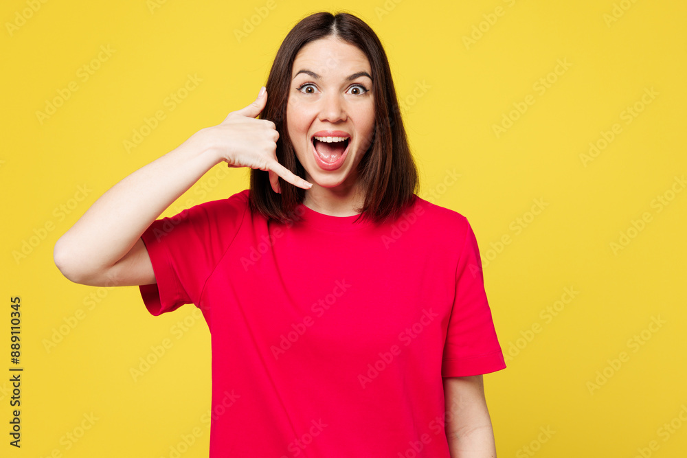 Young surprised shocked excited happy woman wear pink t-shirt casual clothes doing phone gesture like says call me back isolated on plain yellow orange background studio portrait. Lifestyle concept. Young surprised shocked excited happy woman wear pink t-shirt casual clothes doing phone gesture like says call me back isolated on plain yellow orange background studio portrait. Lifestyle concept.