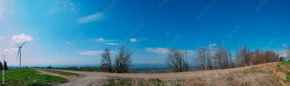 Wind turbine for alternative energy in mountain landscape with clear space background. The concept of clean energy, eco-energetics of the wind. Wind turbine for alternative energy in mountain landscape with clear space background. The concept of clean energy, eco-energetics of the wind.