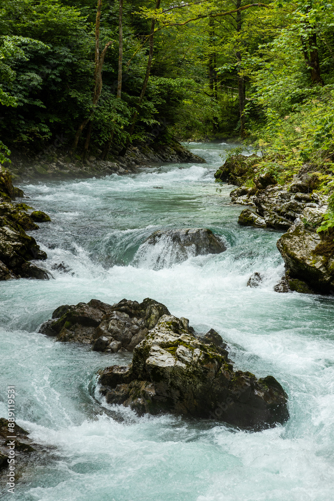 Fototapeta premium Vintgar Gorges Park a few km from Lake Bled, Slovenia. Wooden walkways accompany the path above the river rapids and waterfalls. River hits rocks and creates fog.Adventure family holidays. Freshness.