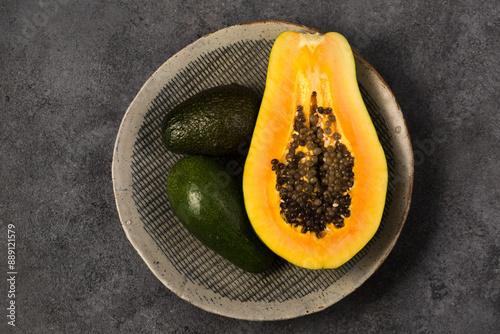 Wallpaper Mural Two avocados and half a papaya on a gray clay plate Torontodigital.ca